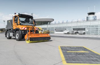 Unimog mit Kehrmaschine auf Flughafen