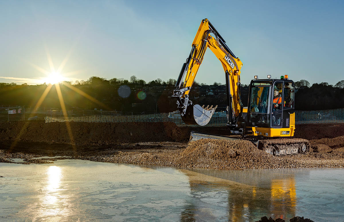 Midibagger JCB 86C-2 arbeitet im Sonnenuntergang