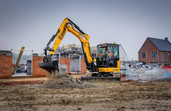 Midibagger JCB 86C-2 mit Verstellausleger im Einsatz mit Schaufel gräbt er im Sand