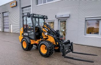 Kompaktradlader JCB 403 vor Henne Firmengebäude in Heimstetten