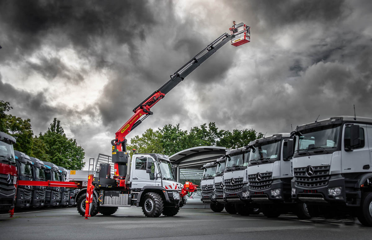 Unimog U535 mit ausgefahrenen Palfinger Ladekran mit montierter Hubarbeitsbühne