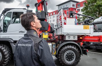 Mercedes-Benz Servicetechniker vor Unimog mit Palfinger Hubarbeitskorb