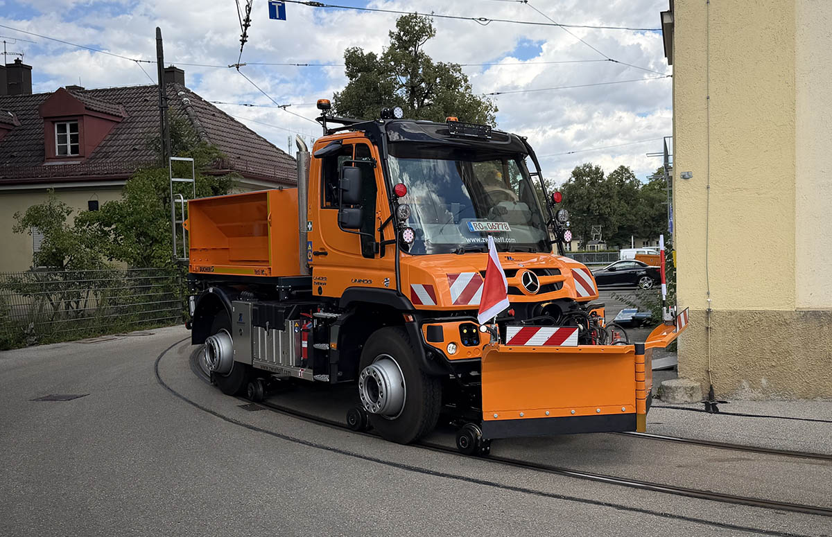 Zwei-Wege-Unimog U 423 im Gleisbogen Unimog U 423 mit Zwei-Wege-Einrichtung und Schneepflug auf Straßenbahngleisen