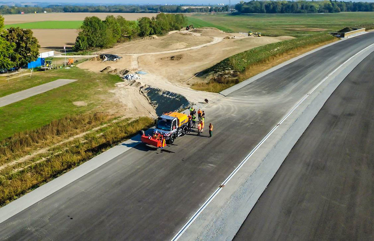 HSWT-Lehrbaustelle – Praxiseinsatz an der A94 Luftaufnahme der HSWT-Lehrbaustelle an der A94 mit Unimog und Studierenden